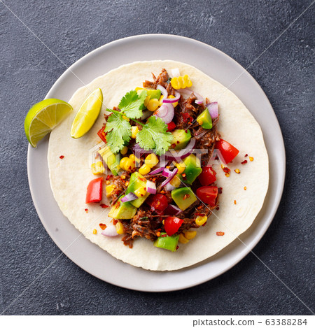 Taco with meat and vegetables. Dark background. Close up. Top view. Taco with meat and vegetables. Dark background. Close up. Top view. 63388284