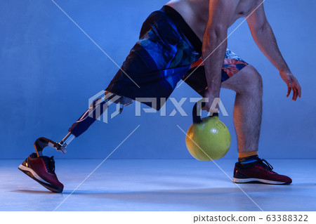 Athlete disabled amputee isolated on blue studio background Athlete disabled amputee isolated on blue studio background 63388322