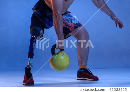 Athlete disabled amputee isolated on blue studio background Athlete disabled amputee isolated on blue studio background 63388325
