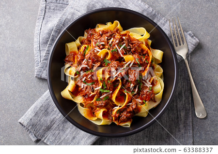 Pasta pappardelle with beef ragout sauce in black bowl. Grey background. Top view. 63388337