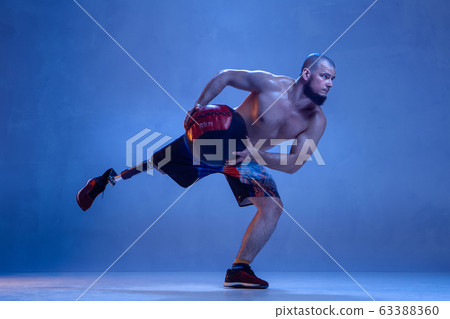 Athlete disabled amputee isolated on blue studio background Athlete disabled amputee isolated on blue studio background 63388360