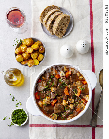 Beef bourguignon stew with vegetables. Grey background. Top view. 63388362