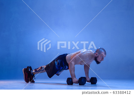 Athlete disabled amputee isolated on blue studio background Athlete disabled amputee isolated on blue studio background 63388412
