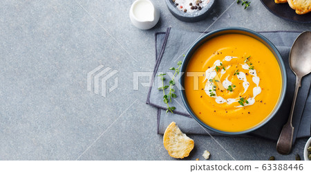 Pumpkin, carrot cream soup in a bowl. Grey background. Top view. Copy space. 63388446