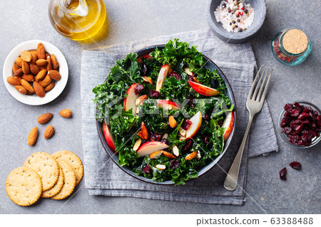 Kale salad with apples, cranberry and nuts. Grey background. Top view. 63388488