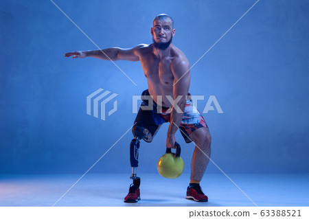 Athlete disabled amputee isolated on blue studio background 63388521