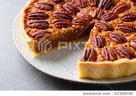 Pecan nut pie, tart on a plate. Grey background. Close up. 63388598