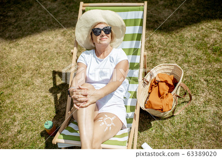 Senior woman on the sunbed outdoors Senior woman on the sunbed outdoors 63389020