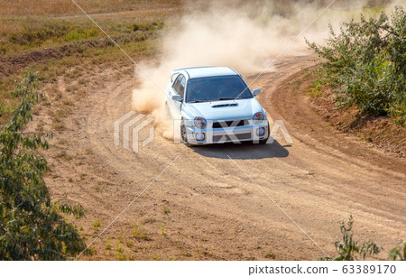 Sports Car and a lot of Dust on a Sharp Turn 63389170