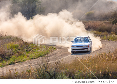 One Rally Car and a lot of Dust on a Sharp Turn 63389172