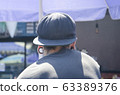 young man view from the back with tonnels in the ears and a cap 63389376
