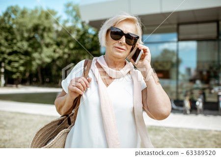 Senior woman with phone in the city 63389520
