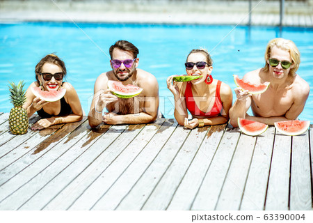 Friends with watermelon on the swimming pool outdoors 63390004