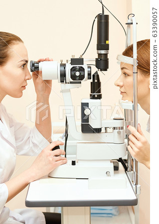 ophthalmologist doctor in exam optician laboratory with female patient. Eye care ophthalmologist doctor in exam optician laboratory with female patient. Eye care 63390057