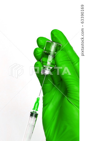 Person in gloves hold vaccine bottle with syringe 63390169