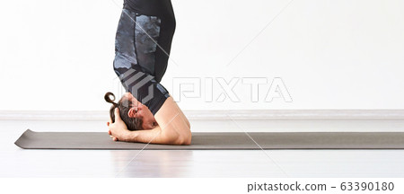 Man yoga class. Black wear. Calm relax sirsasana pose 63390180
