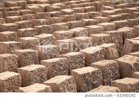 Traditional homemade production of raw clay brick laid out in stacks for drying on brick factory Traditional homemade production of raw clay brick laid out in stacks for drying on brick factory 63390192