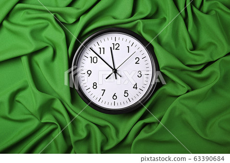 White clock over green textile folded pleats 63390684