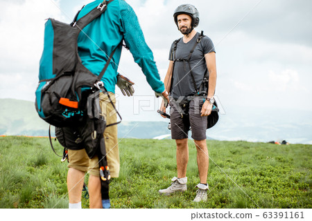 Men preparing for the paraglider flight 63391161