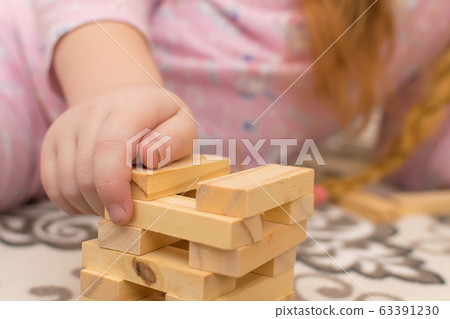 hands of a little girl, a child who plays sitting on the floor of the house 63391230