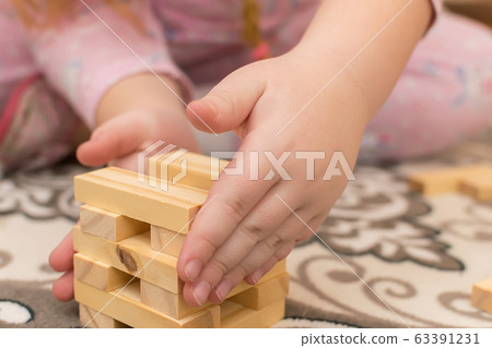 hands of a little girl, a child who plays sitting on the floor of the house hands of a little girl, a child who plays sitting on the floor of the house 63391231