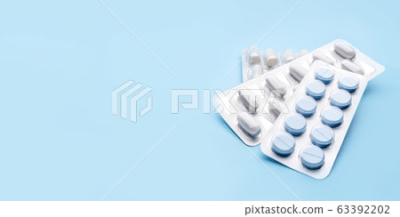 Pills in blister packs on blue background. Pills in blister packs on blue background. 63392202
