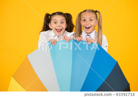 Umbrella surprise. Surprised girls hiding behind Umbrella surprise. Surprised girls hiding behind 63392718