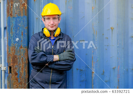 Portrait of technician or worker man with action of confident stand in front of cargo container Portrait of technician or worker man with action of confident stand in front of cargo container 63392721