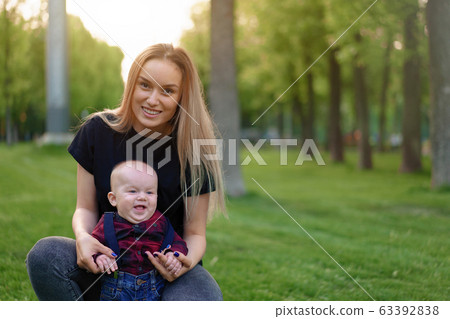Beautiful young mother walks with her little son in a summer park 63392838