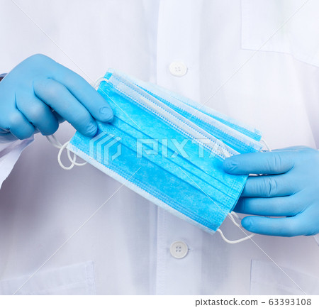 doctor in a white coat, blue latex sterile gloves doctor in a white coat, blue latex sterile gloves 63393108