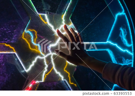 Electricity, science and physics concept - woman touching plasma panel display 63393553