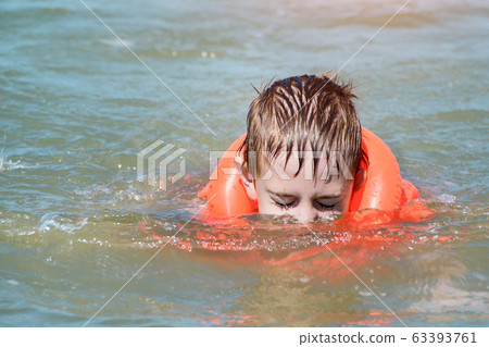Child learn to swim with inflatable vest. Safe 63393761