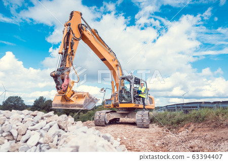 Woman construction worker with excavator on site Woman construction worker with excavator on site 63394407