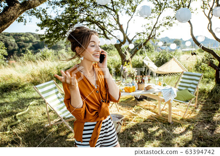 Woman talking phone in the decorated backyard 63394742
