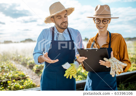 Man and woman on the farmland for snails growing outdoors 63396106