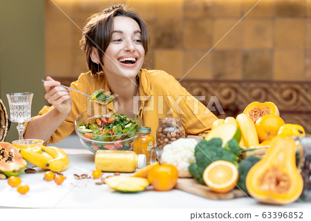 Young woman with healthy fresh food on the kitchen Young woman with healthy fresh food on the kitchen 63396852