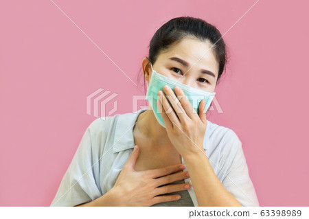 Young asian woman worea gray tank top, Blue shirt and protective masks against virus and air pollution,make gesture Coughing, isolated on pink background Young asian woman worea gray tank top, Blue shirt and protective masks against virus and air pollution,make gesture Coughing, isolated on pink background 63398989