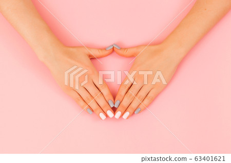 Delicate hands with natural manicure, clean skin. Light pink gray nails. 63401621