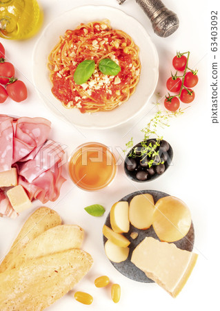 Italian food. Pasta, cheese, ham, wine, tomatoes, shot from above on a white background Italian food. Pasta, cheese, ham, wine, tomatoes, shot from above on a white background 63403092