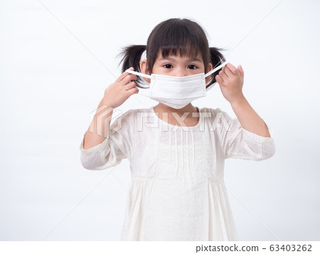 Asian little cute girl 4 years old wearing a hygienic face mask to protective spread the disease on white background. Prevention of spreading the corona virus COVID-19 cold flu or pollution. Asian little cute girl 4 years old wearing a hygienic face mask to protective spread the disease on white background. Prevention of spreading the corona virus COVID-19 cold flu or pollution. 63403262