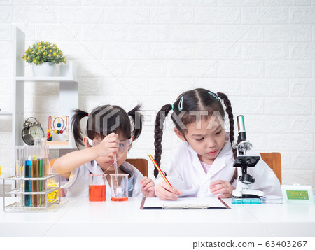 Two little asian sibling girl role playing a scientist in science lab with equipment. Learning and education of kid. Two little asian sibling girl role playing a scientist in science lab with equipment. Learning and education of kid. 63403267