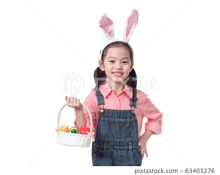 Happy little cute girl 6 years old wearing rabbit ears and holding easter eggs basket isolated on white background with clipping part. Happy little cute girl 6 years old wearing rabbit ears and holding easter eggs basket isolated on white background with clipping part. 63403276