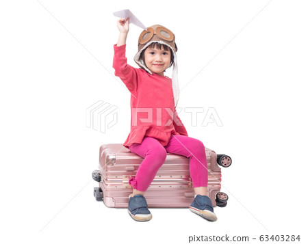 Asian little cute girl 4 years old wear pilot hat and sitting on pink luggage with holding paper airplane isolated on white background. Asian little cute girl 4 years old wear pilot hat and sitting on pink luggage with holding paper airplane isolated on white background. 63403284