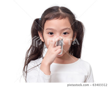 Asian little cute girl 6 years old using asthma inhaler on white background. 63403312