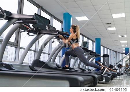 Young sporty Woman On Running Machine In Gym Young sporty Woman On Running Machine In Gym 63404595