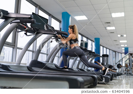 Young sporty Woman On Running Machine In Gym 63404596