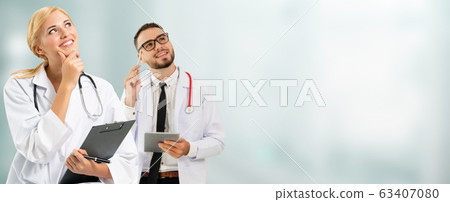 Doctor at hospital works on computer with partner. 63407080