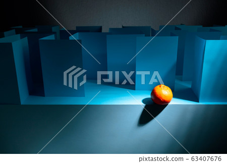Tangerine in paper labyrinth. Concept of theme of 63407676