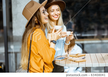 Girlfriends spending time together on a cafe terrace 63408041