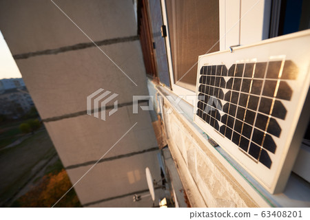 Solar panel on the window of a high-rise residential building, urban blurred background Solar panel on the window of a high-rise residential building, urban blurred background 63408201